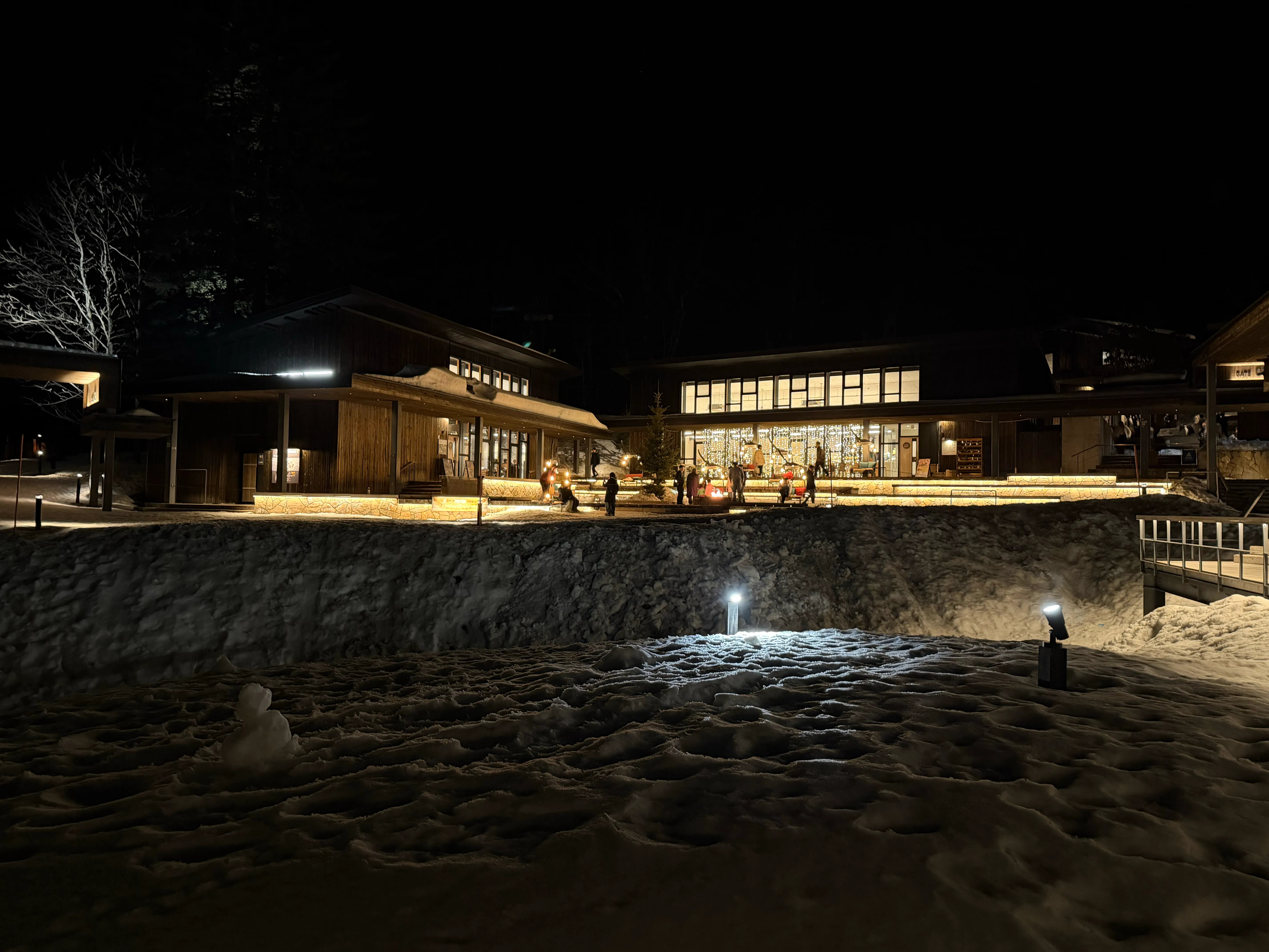 夜のトマム。雪面に反射するライトアップと温かみのある建物の光