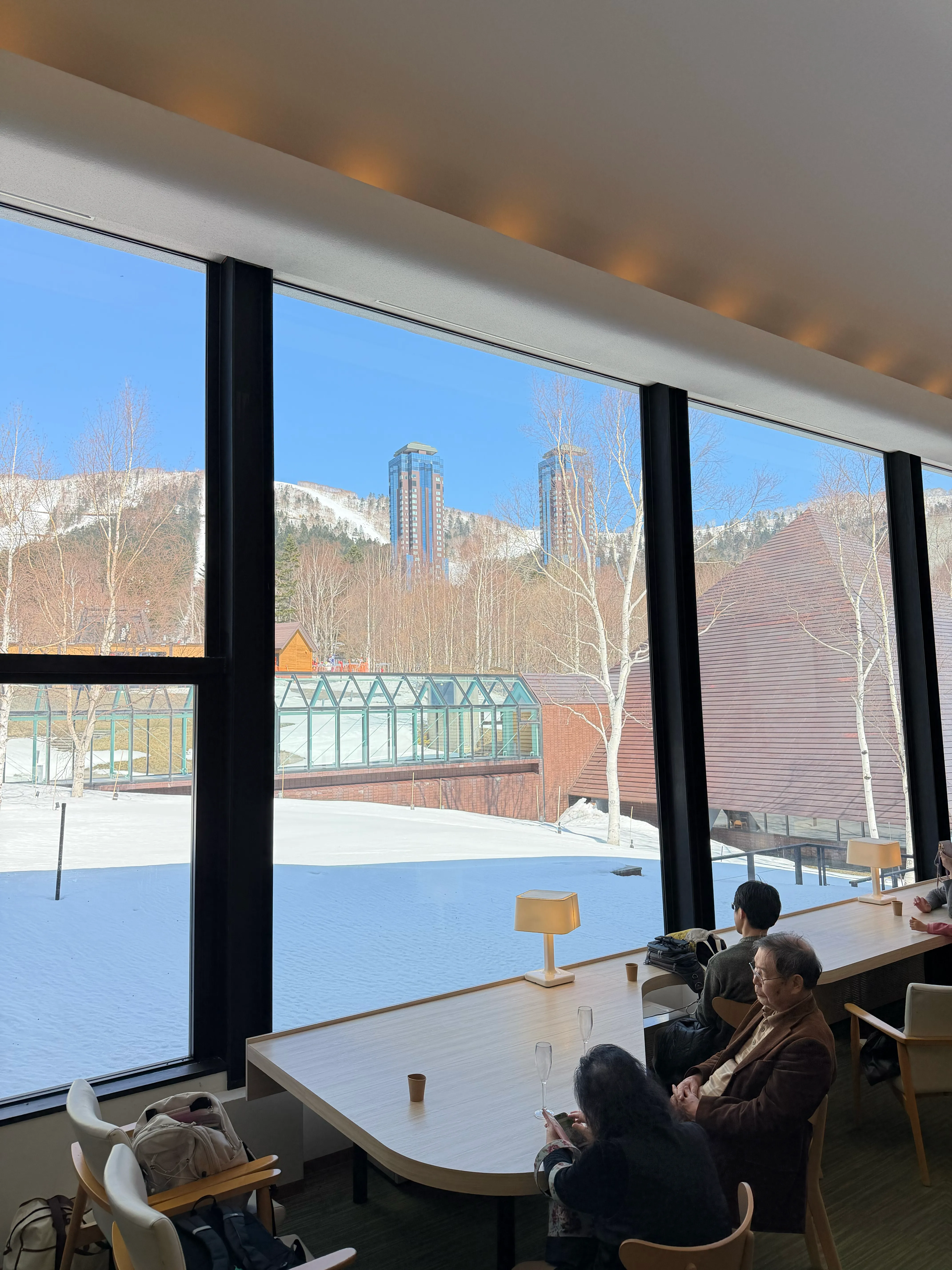 ビュッフェダイニングhalの大きな窓。雪が残る景色とトマムリゾートの建物が広がる