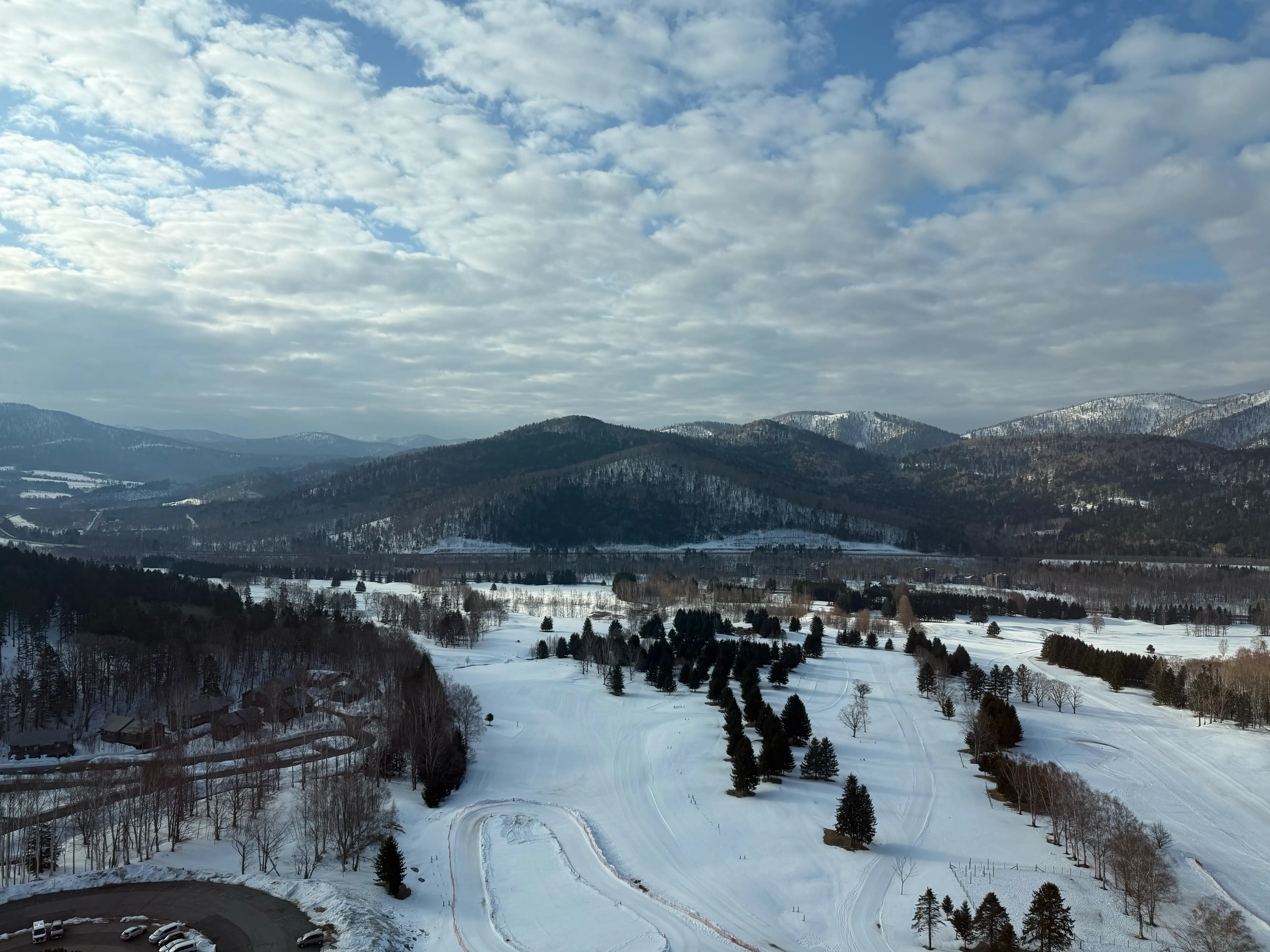 トマム・ザ・タワーの部屋の窓から見渡す雪景色。広大な白い平野と山並みが広がる