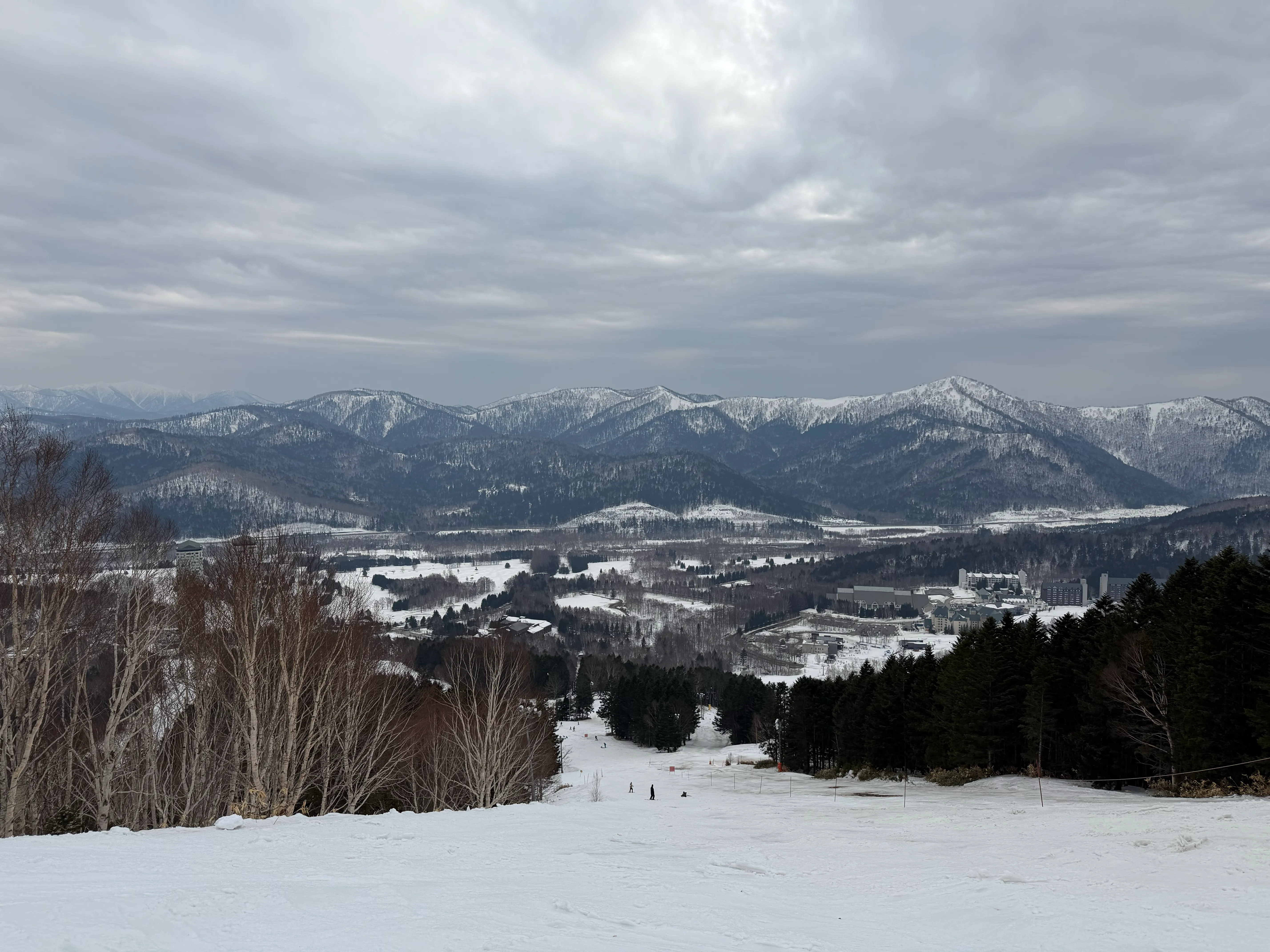 山頂から見渡すトマムの広大な景色。雪に覆われた山並みとリゾートが広がる