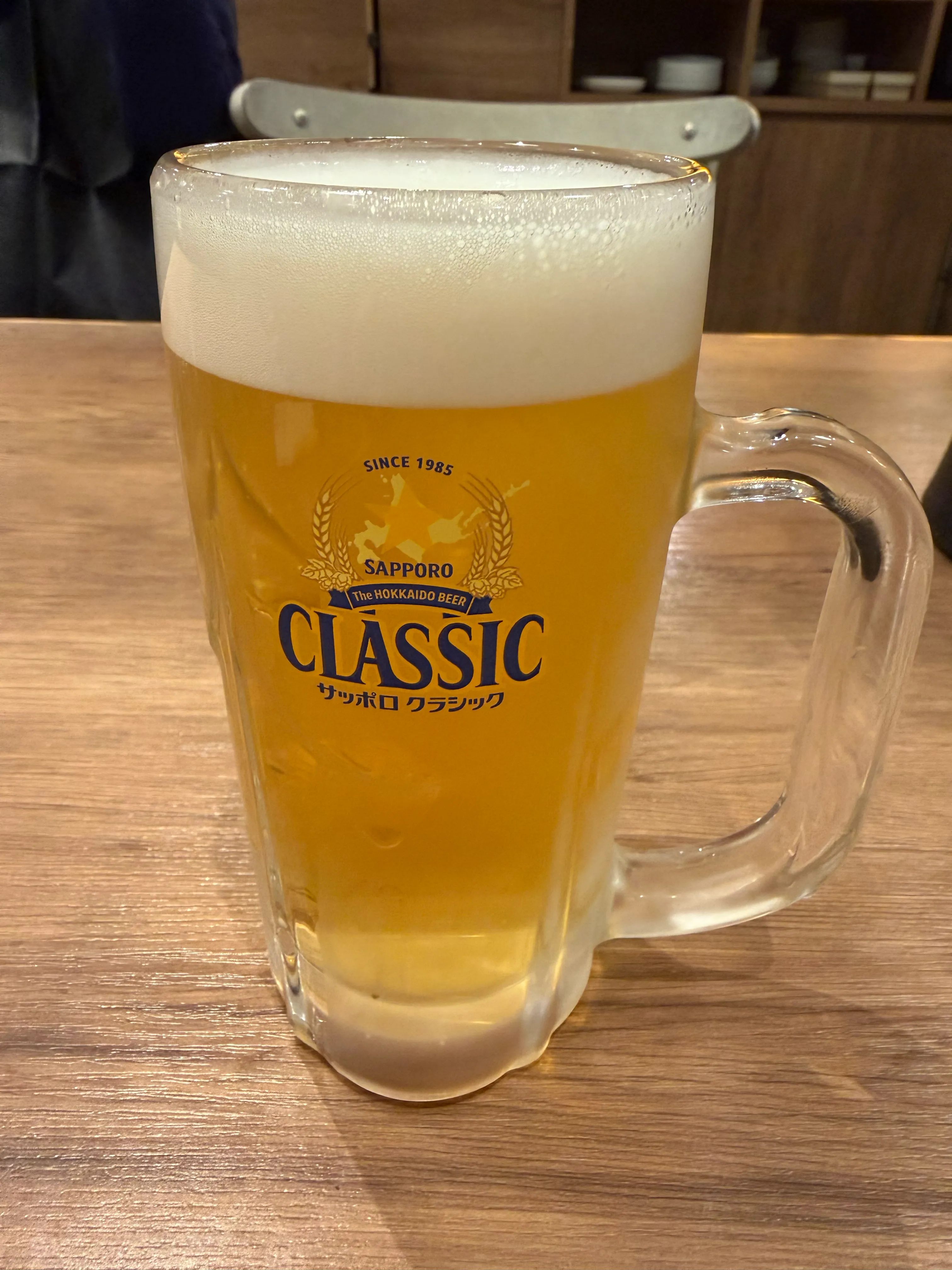サッポロクラシックの大ジョッキ。琥珀色の泡立つビールがテーブルに届く