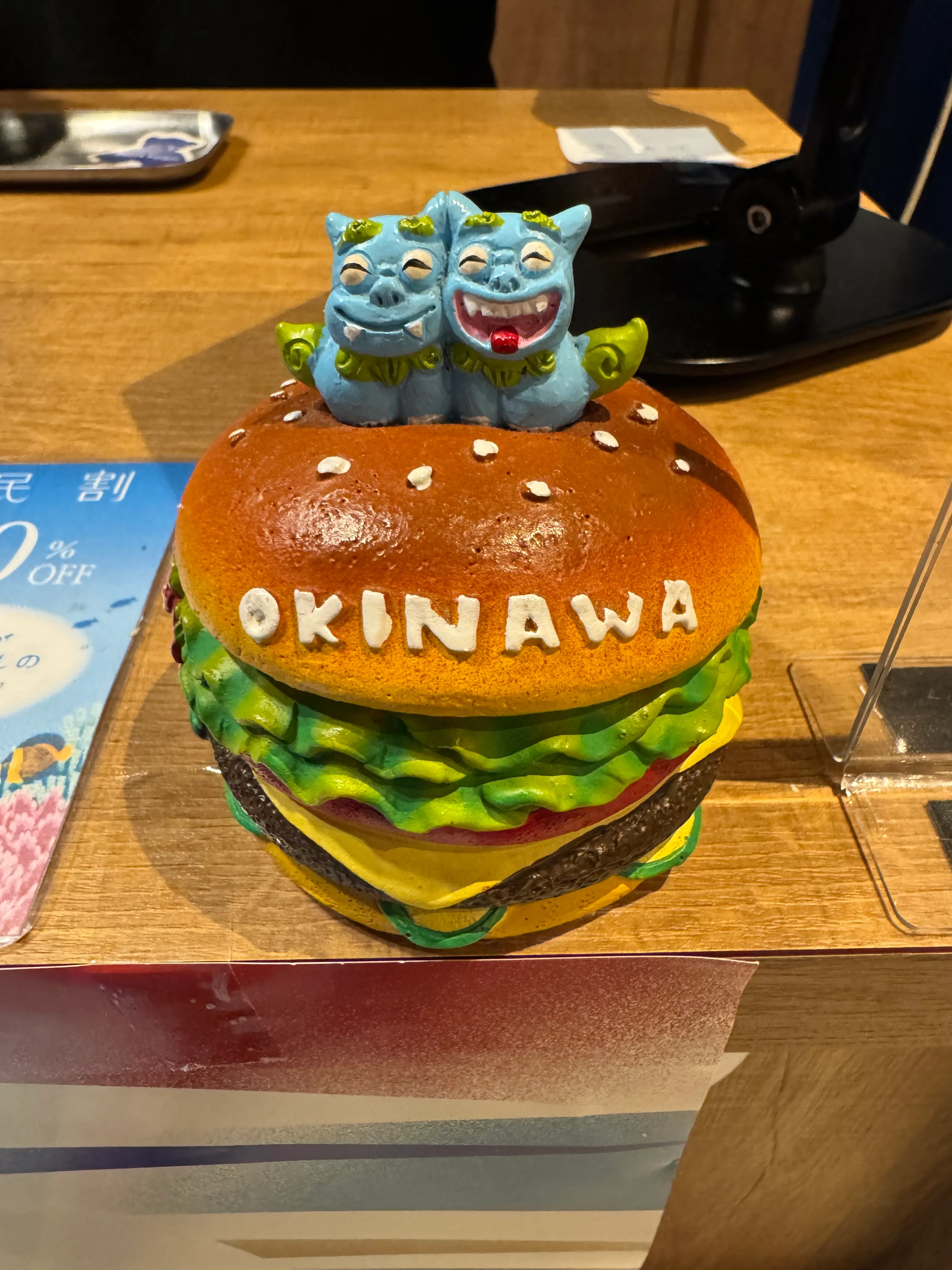 レジ横のマスコット。シーサーがOKINAWAと書かれたバーガーの上に乗ったフィギュア