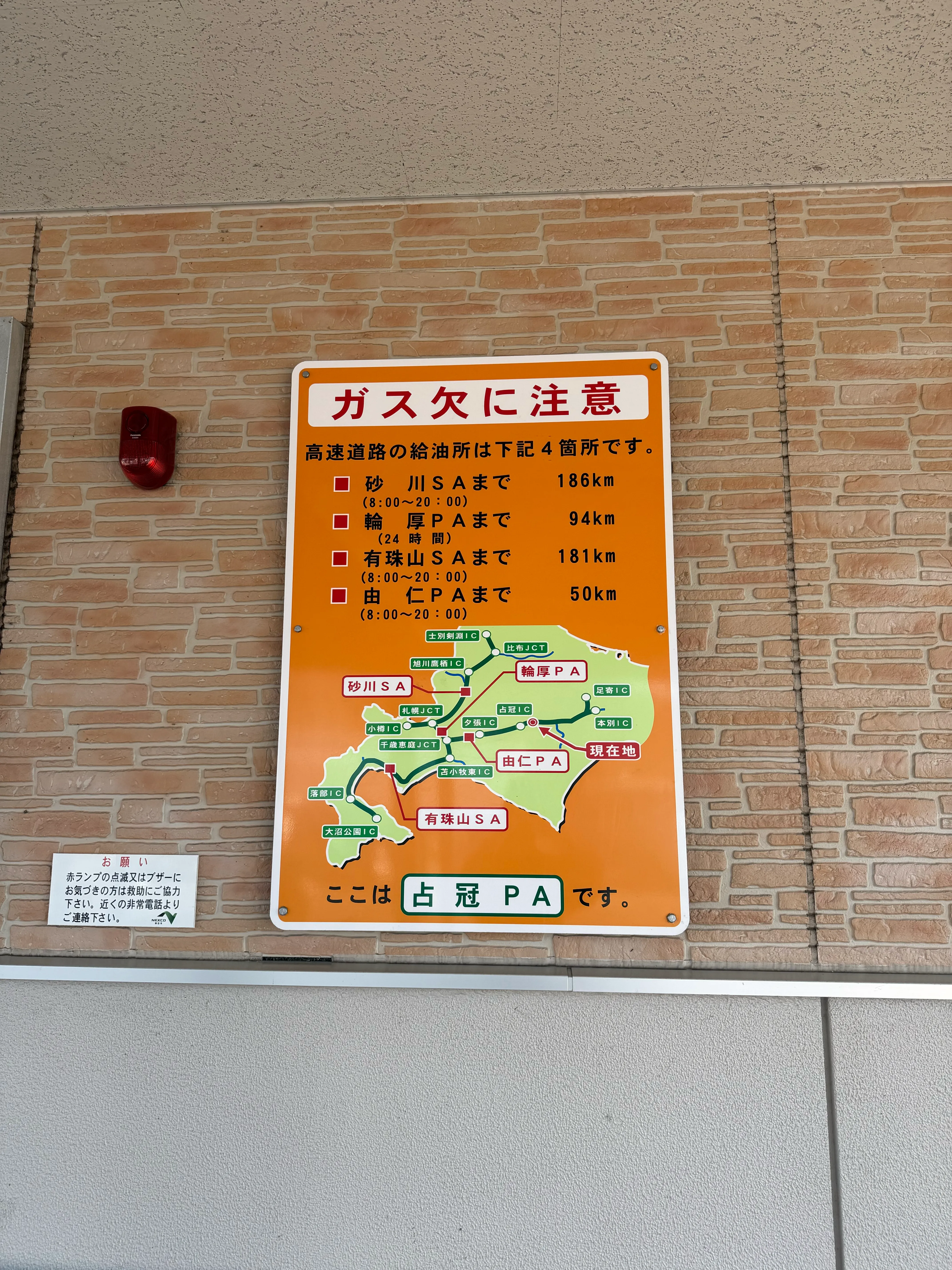 高速道路上の古瀬PA内の注意看板。北海道の地図とともに高速道路上のガス欠注意スポットが示されている