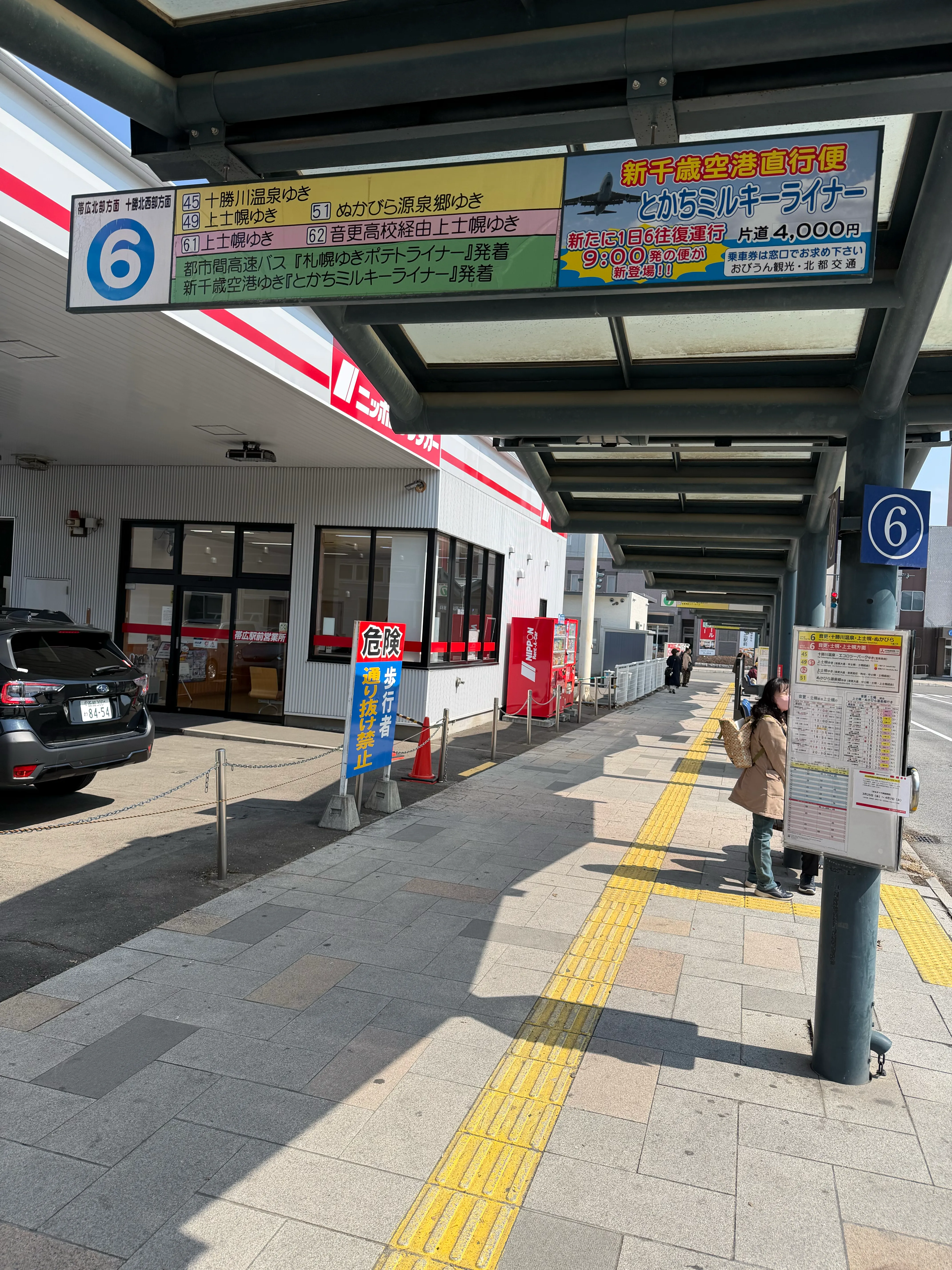 バスターミナルの9番乗り場。バスが並んで停車し、案内板に行先が表示されている