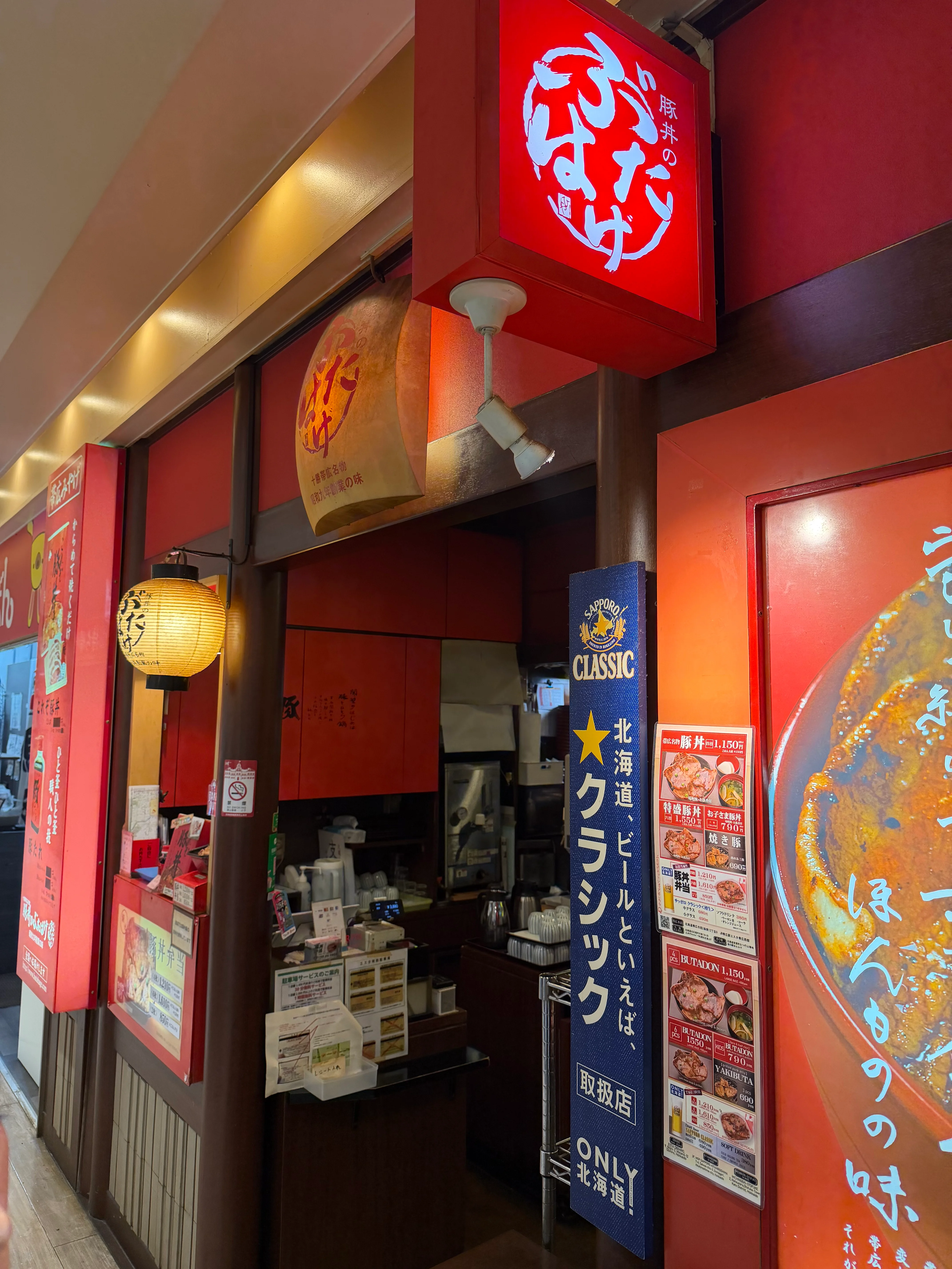 ぶたはげの店外観。赤い看板と暖簾が目を引く