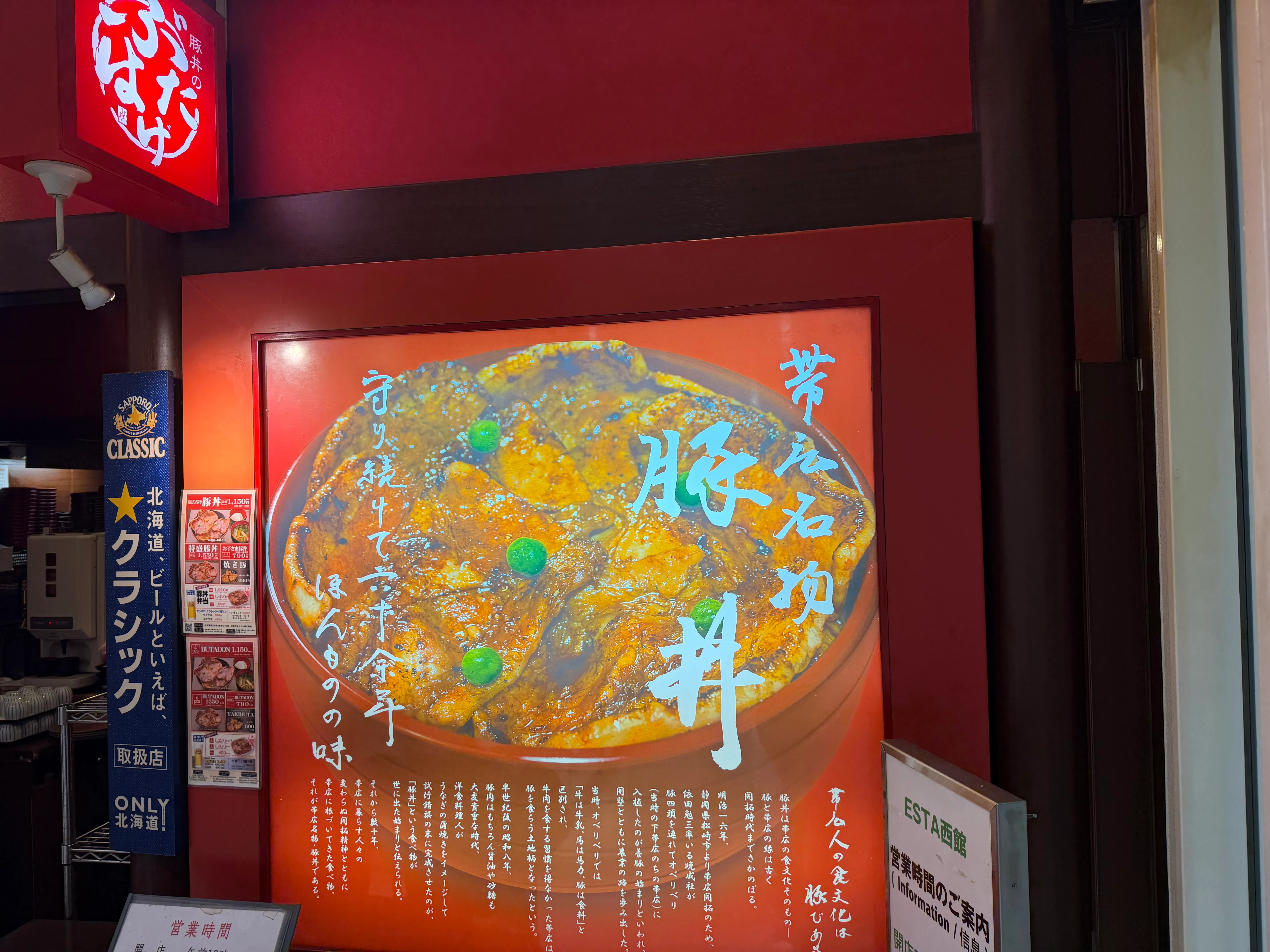 店頭に掲げられた「芽室石坂 豚丼」の大きな看板ポスター