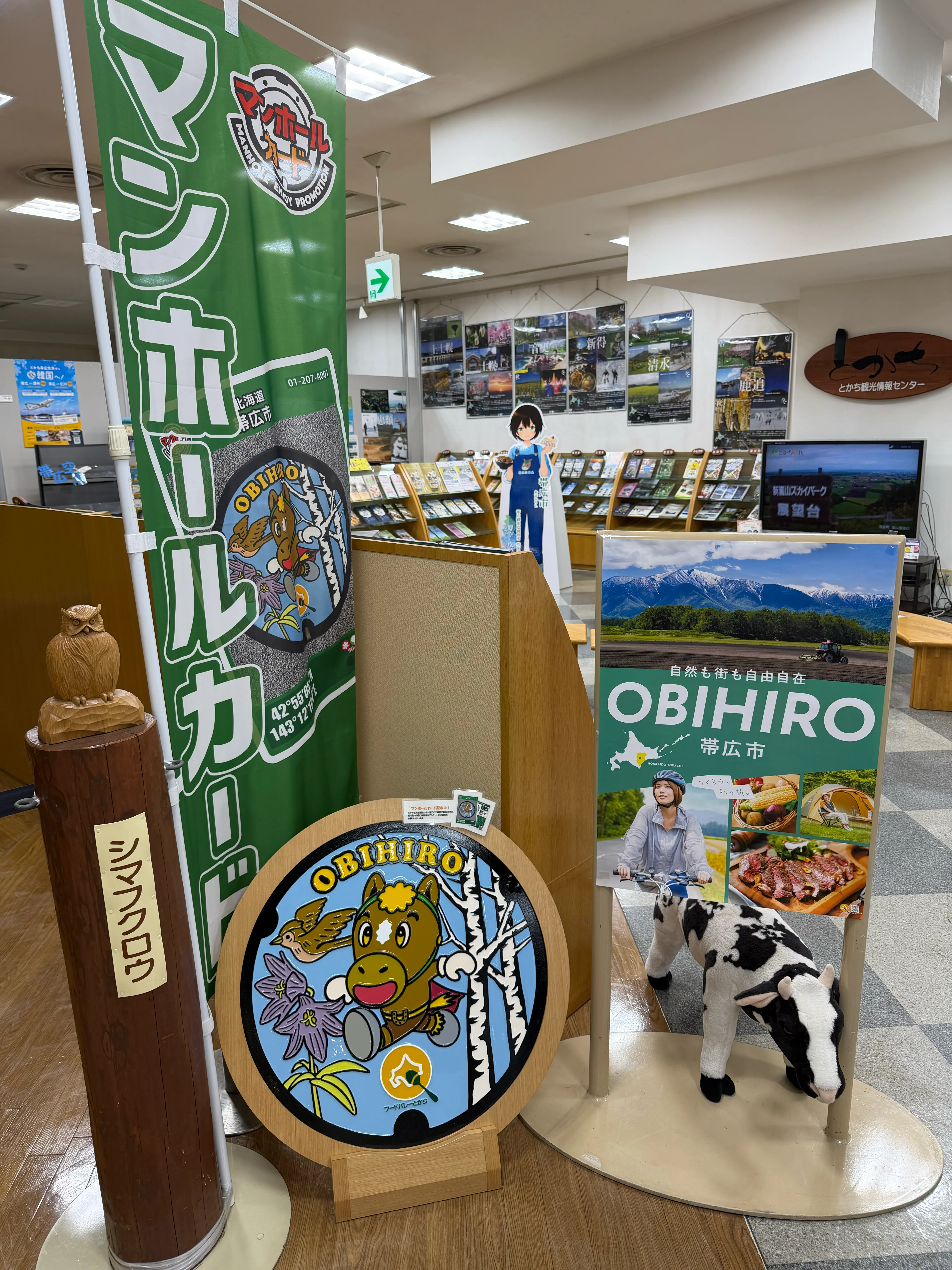 帯広市の観光情報センター内。OBIHIROの大きなパネルと、カラフルなマンホール蓋のレプリカが並ぶ