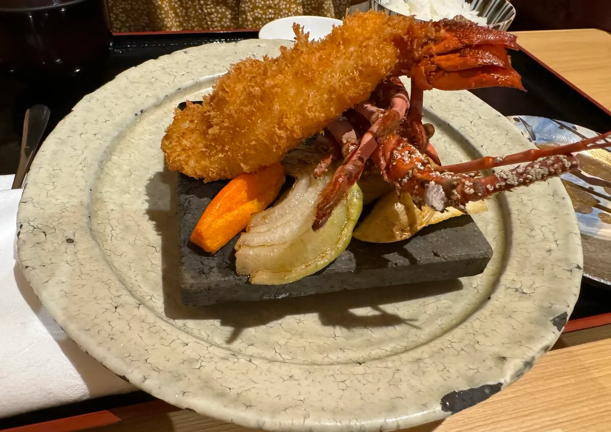 伊勢海老のフライ。石板の上にこんがり揚げられた伊勢海老が盛られている
