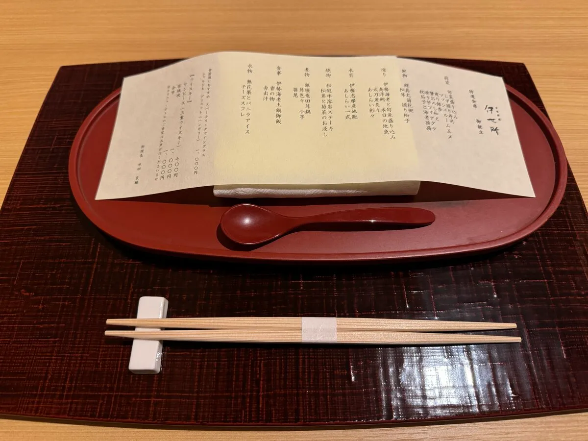 伊勢神泉の夕食コースのメニュー表。漆塗りのお盆に和紙のコース献立が置かれている