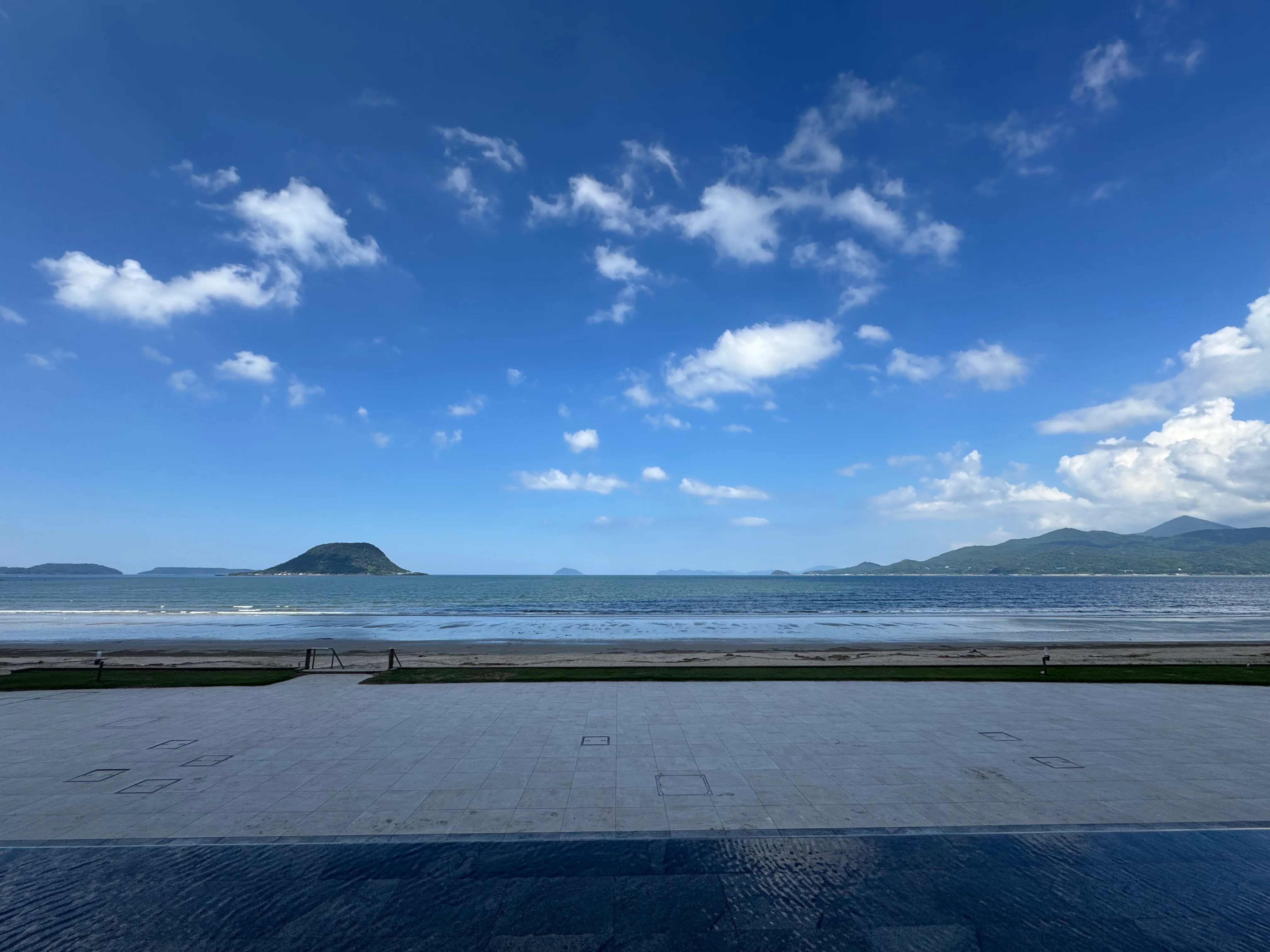 唐津シーサイドホテルから見た唐津湾の絶景。青空のもと、海に浮かぶ緑の島々が広がる