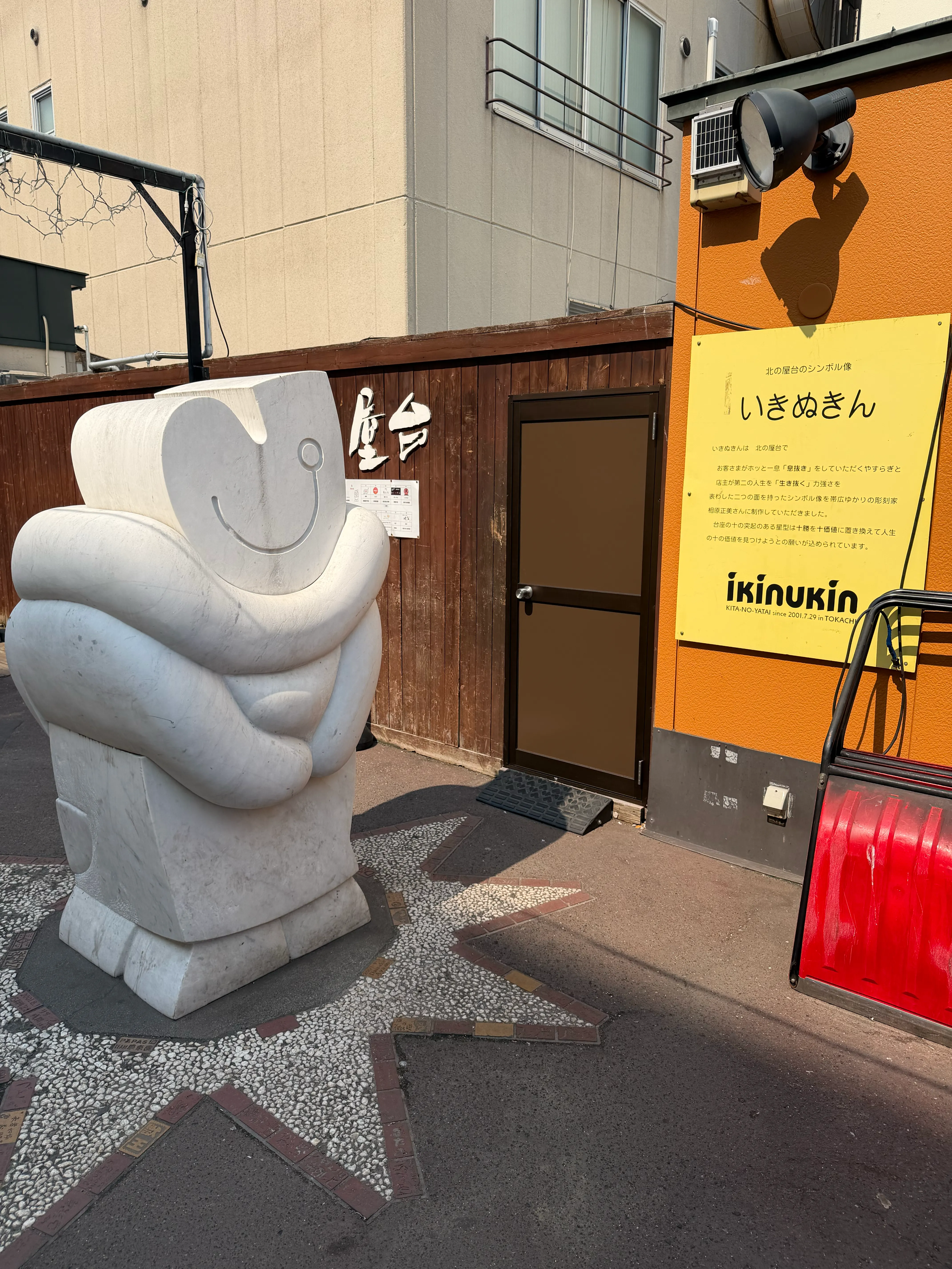 いきぬきん彫刻と、黄色い「ikinukin」解説パネル。作品名と説明文が英語と日本語で書かれている