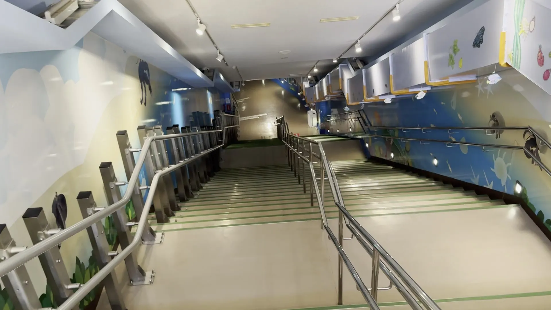 宮古島海中公園の地下へと続く階段。左右の壁は空と海中のイラストで装飾されている