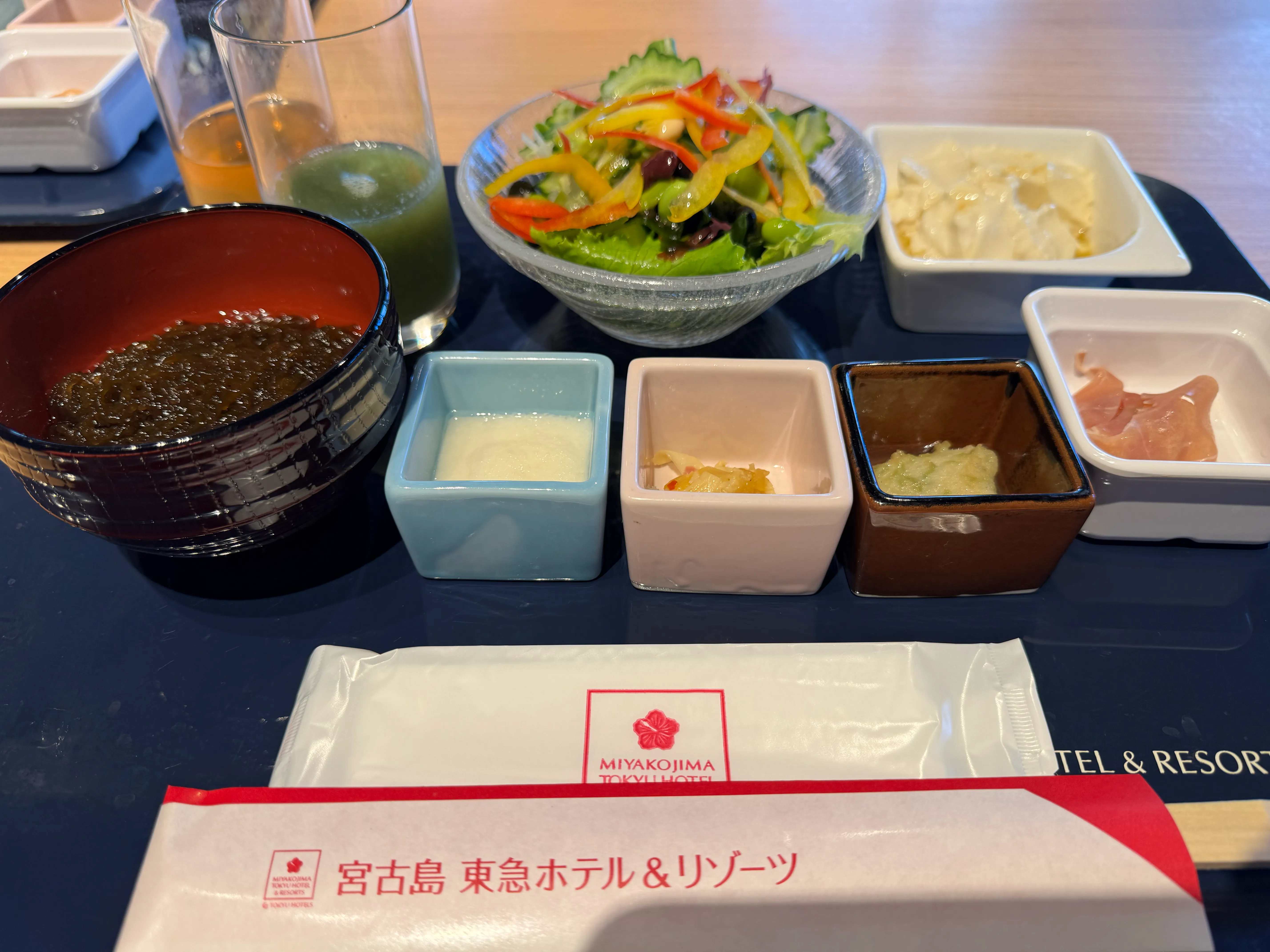 チェックアウト日の朝食ビュッフェ。東急ロゴのプレースマット・もずく・小鉢・サラダ