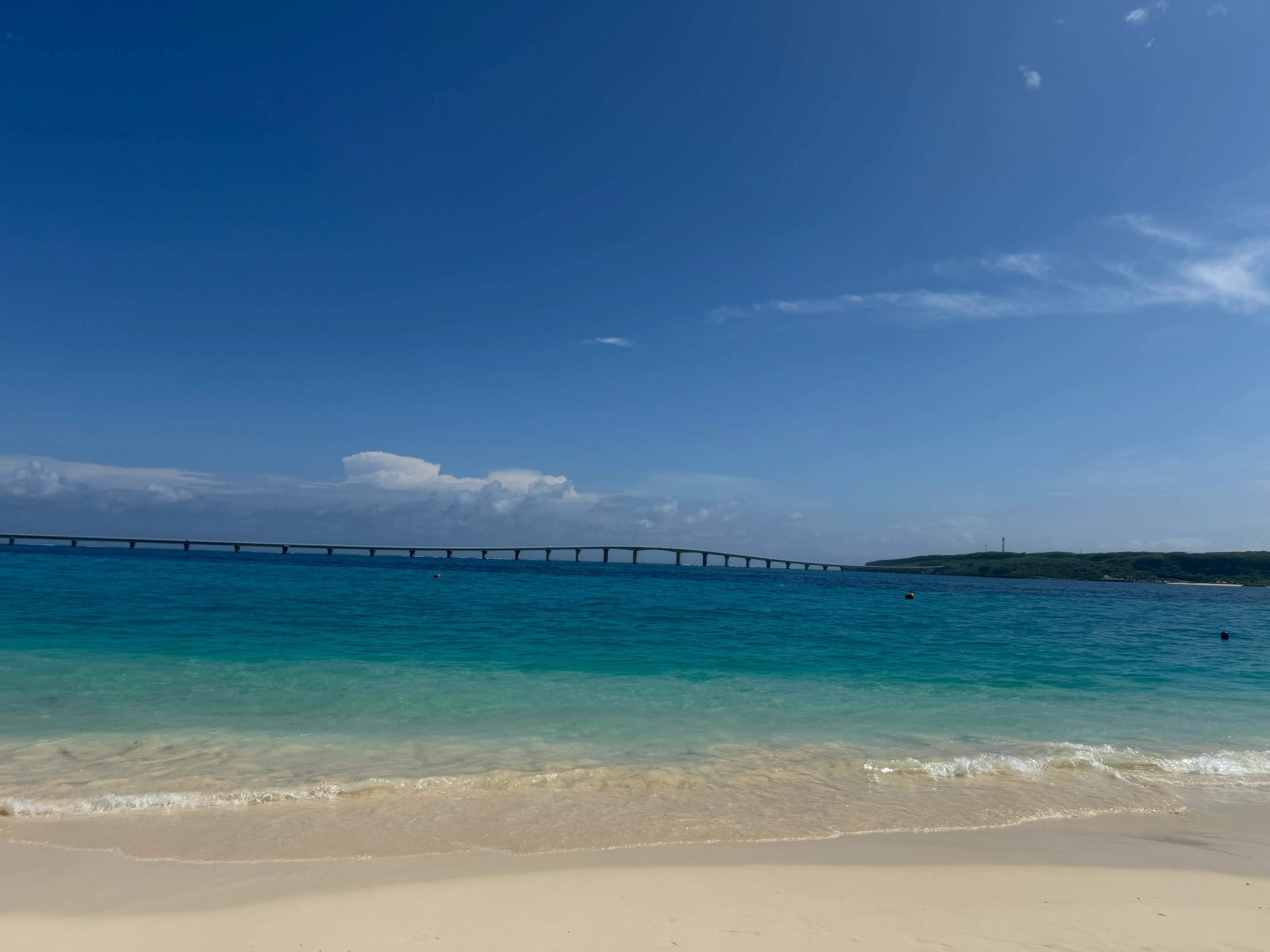 与那覇前浜の白砂と宮古ブルーの海、遠くに伸びる来間大橋。スケールの大きい7kmのビーチ