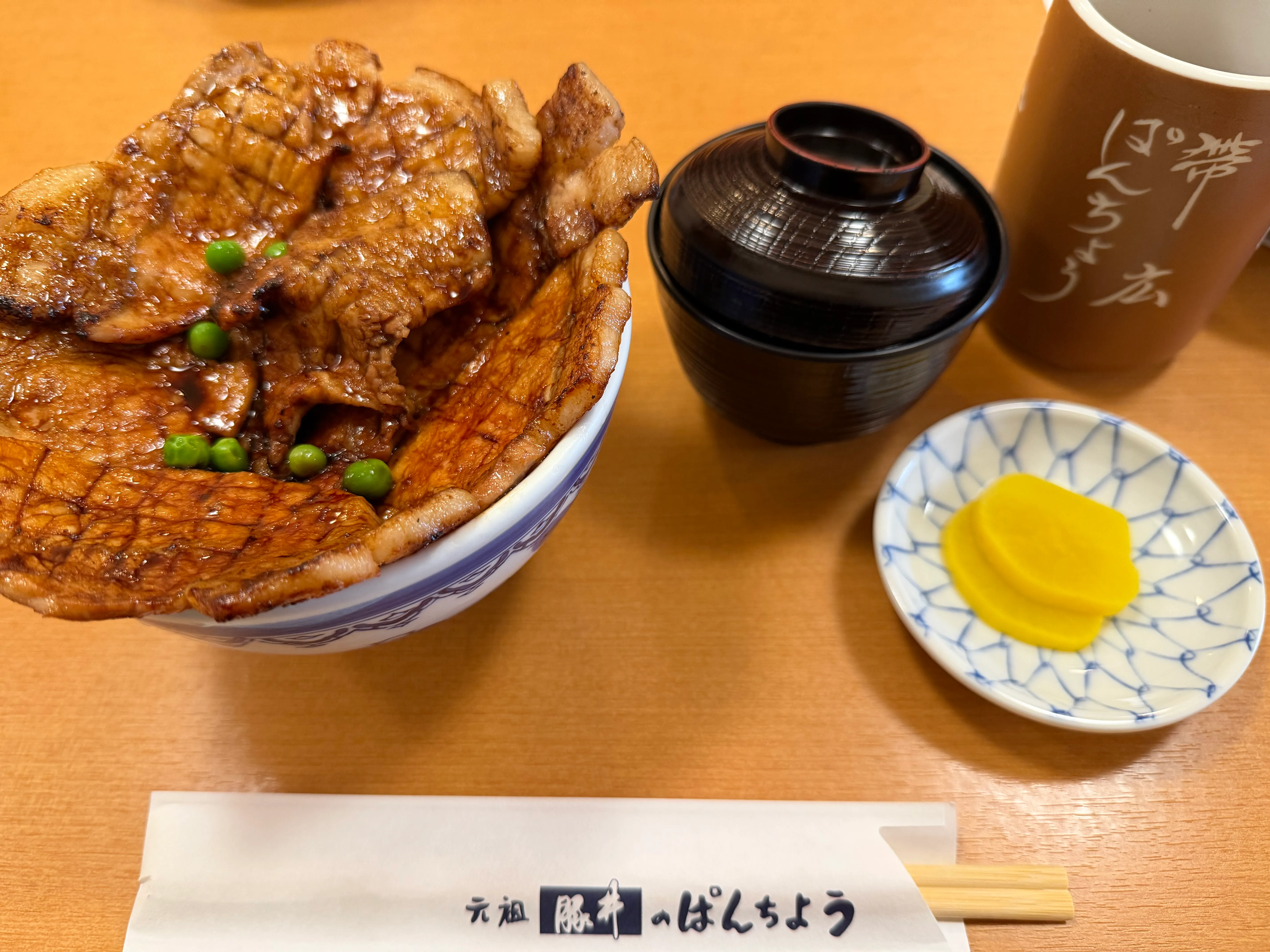 蓋を外した豚丼。炭火焼きの豚肉がご飯をほぼ覆いつくすほど盛られている