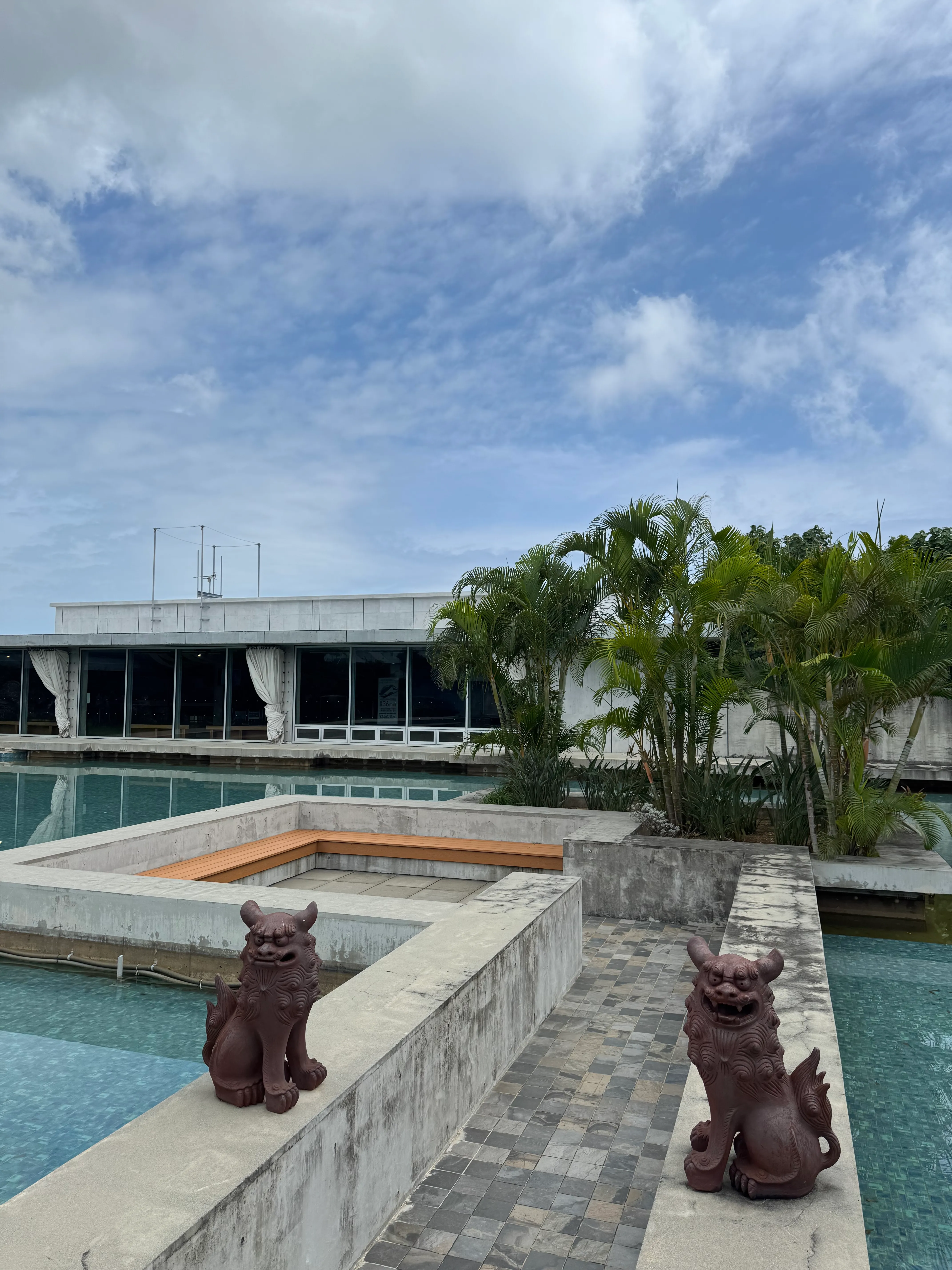 下地島空港の外観。シーサー像とヤシの木、青空が広がる