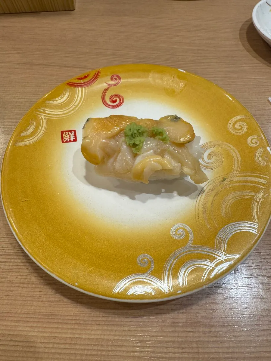 トリトンの真だちの握り1貫。とろけるような白子が金の皿に乗っている