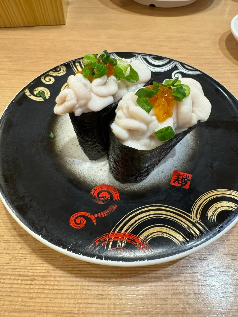 トリトンの真だち軍艦2貫。ぷるぷるの白子が黒い皿に盛られている