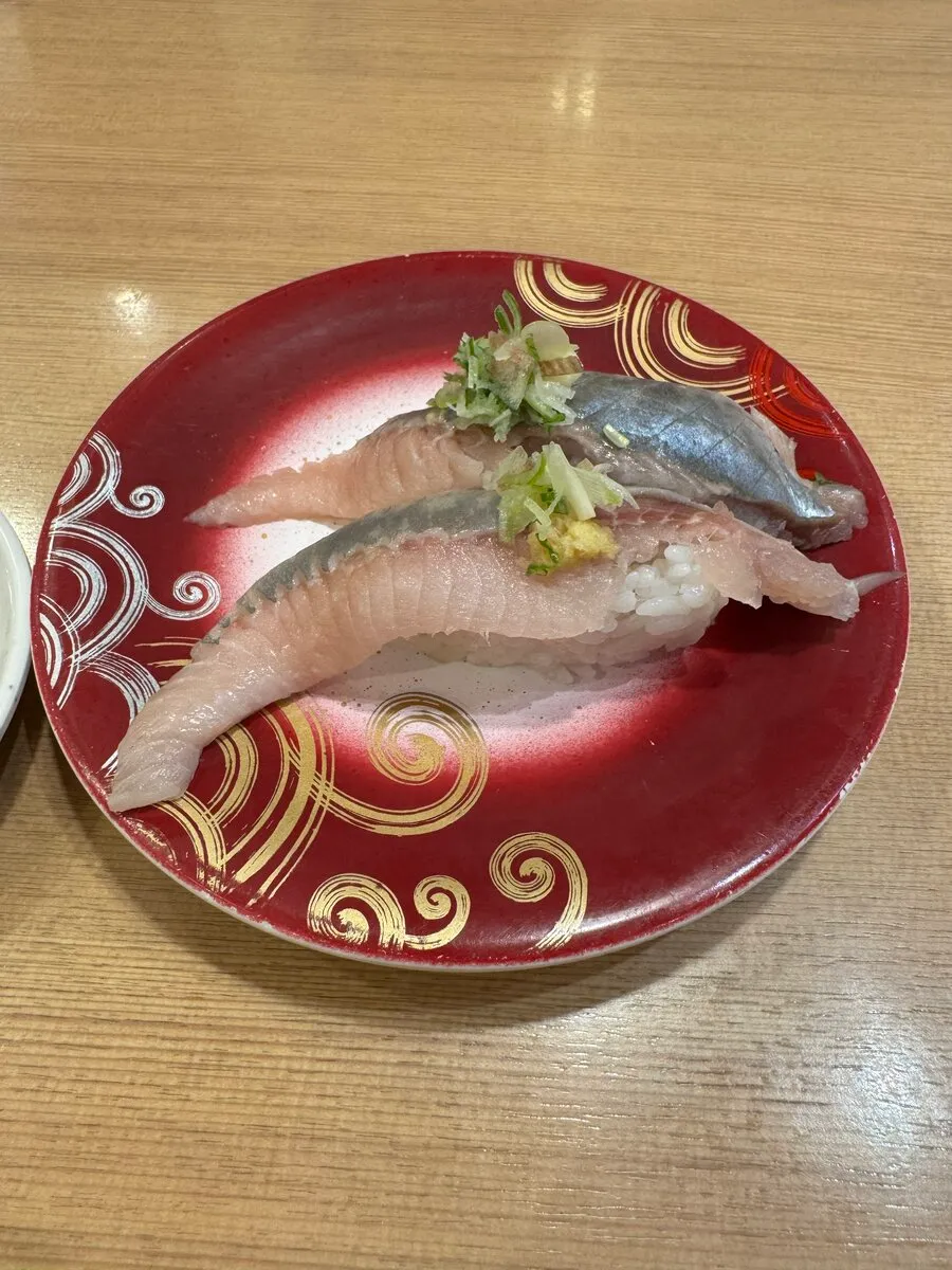 トリトンのにしんの握り2貫。脂がのった身が赤い皿に盛られている